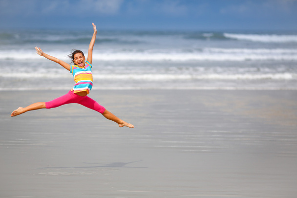 Girl jumping on the beach - 写真・画像