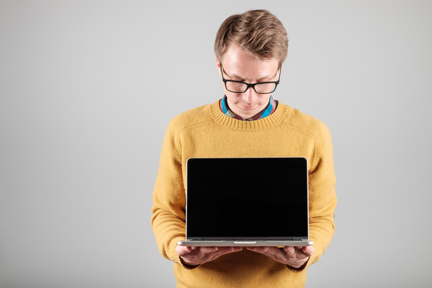Man presenting something on blank laptop screen - Фото, изображение