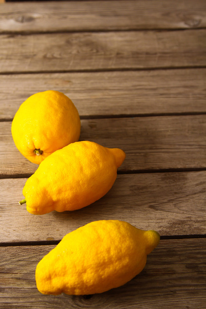 Fresh lemons on a wooden table - Φωτογραφία, εικόνα