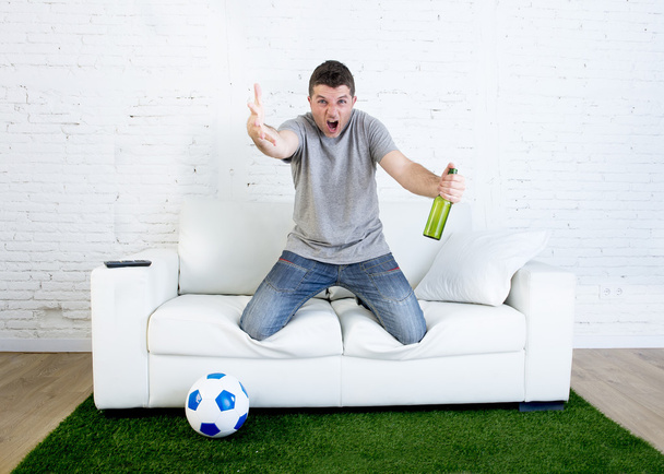 enojado fanático del fútbol viendo partido en la televisión sosteniendo cerveza gesto molesto y loco enojado quejándose
 - Foto, Imagen