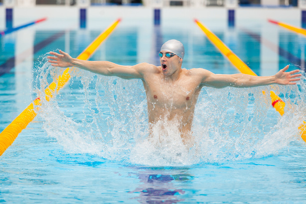 dynamic and fit swimmer in cap breathing performing jumping out the water, concept of victory, freedom, happiness, healthy lifestyle - Φωτογραφία, εικόνα