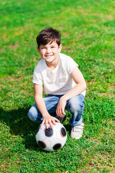 Cute small boy is playing football with joy - Photo, Image