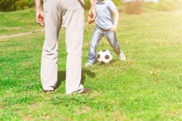 Cute grandchild and grandparent playing football together - Zdjęcie, obraz