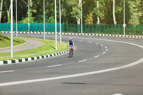 Mujer ciclista monta una bicicleta de carreras en la carretera
 - Foto, Imagen