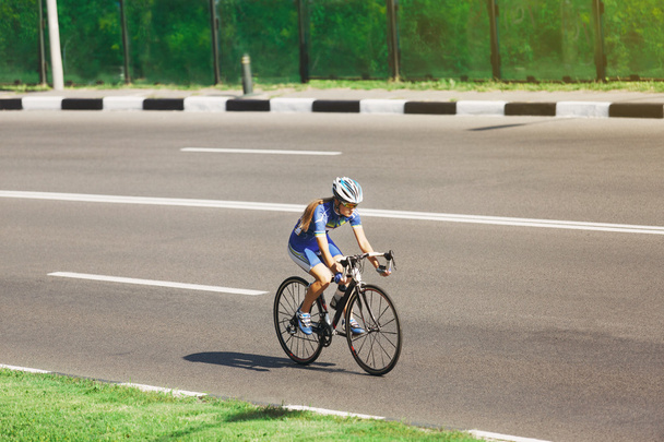 Kobiet rowerzysta jeździ na rowerze wyścigowym na drodze - Zdjęcie, obraz