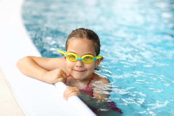 Schoolgirl with goggles in swimming pool - Photo, Image