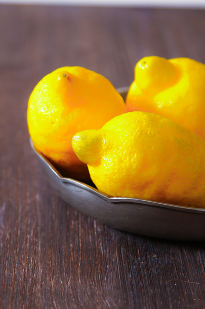Fresh lemons on a wooden table. - Φωτογραφία, εικόνα