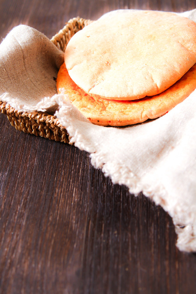 freshly baked pita bread on a wooden table close-up. rolling pin - Zdjęcie, obraz