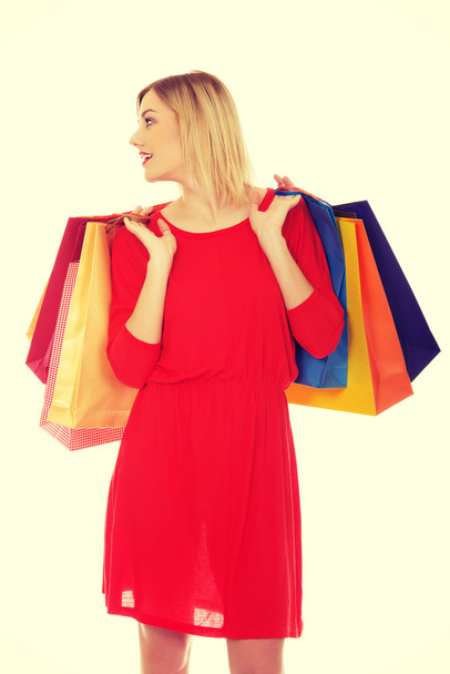 Young happy smiling woman holding shopping bags - Foto, Bild