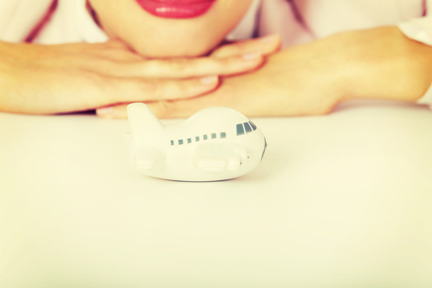Closeup photo of business woman lying on the desk with toy plane - Foto, Bild
