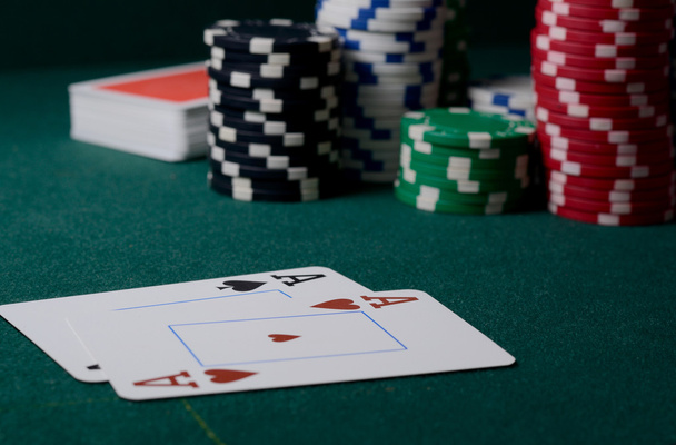 Fichas de casino e par de ases na mesa verde. Jogo de poker
 - Foto, Imagem