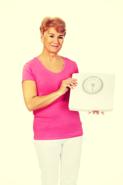 Smiling old woman holding weight scale - Photo, Image