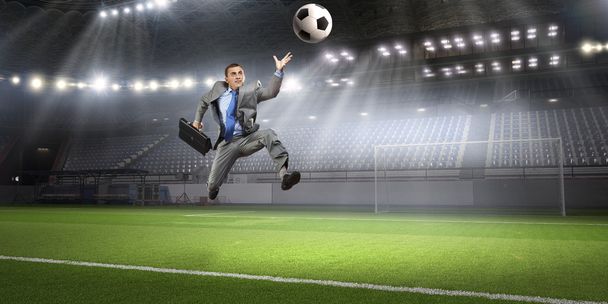 Businessman kicking ball - Φωτογραφία, εικόνα