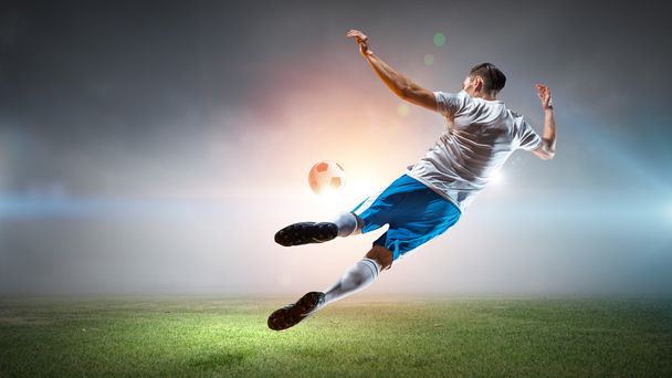 サッカー プレーヤーがボールを打つ - 写真・画像