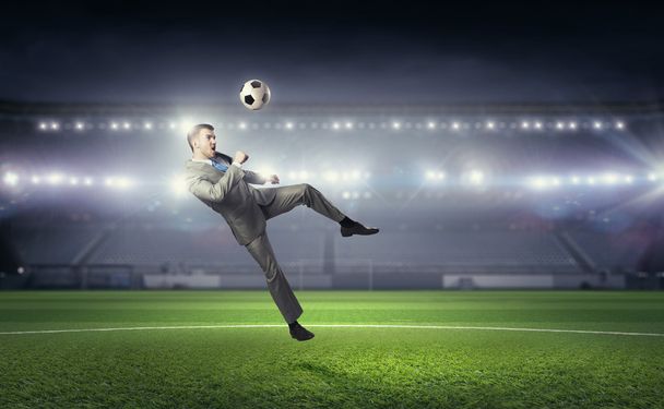 Businessman kicking ball - Фото, изображение