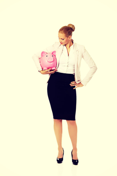 Young business woman holding piggybank - Фото, изображение