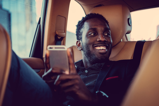 Hymyilevä musta mies älypuhelimella
 - Valokuva, kuva