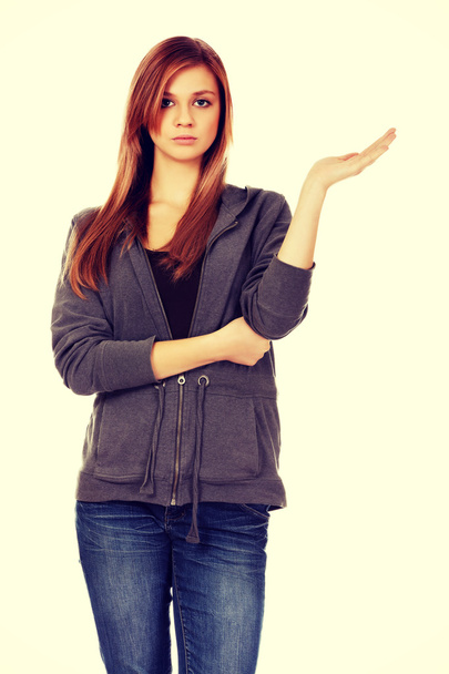 Teenage woman presenting something on open palm - Fotó, kép