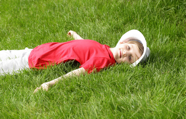 garçon est couché sur l'herbe verte dans le parc
  - Photo, image