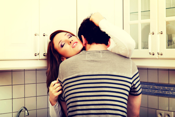 Ρομαντικό ζευγάρι φιλιούνται στην κουζίνα. - Φωτογραφία, εικόνα