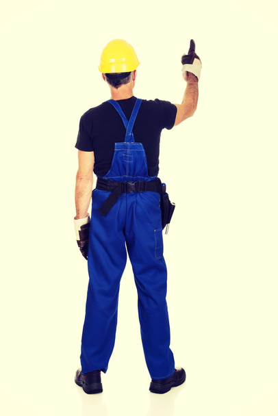 Repairman wearing hard hat pointing up - Foto, imagen