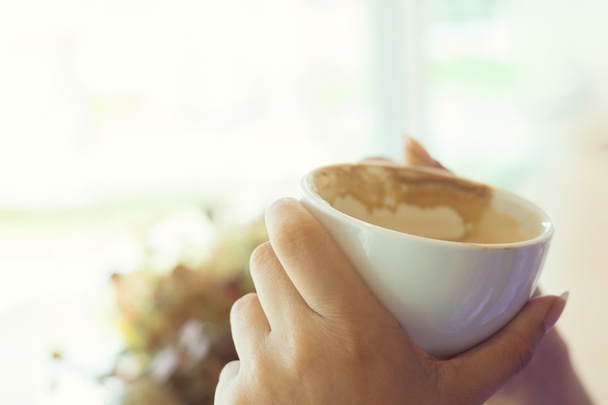 ręka trzymać kubek gorącej kawy w kawiarni - Zdjęcie, obraz