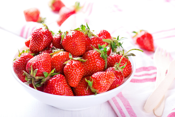 verse aardbeien in witte kom met het servet - Foto, afbeelding