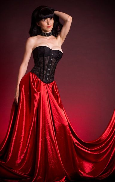 Sexy jeune femme en robe de mode sur fond rouge
. - Photo, image