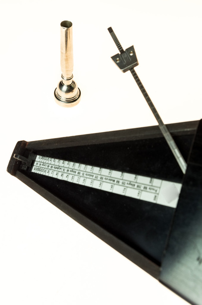 Μετρονόμο και επιστόμιο του μια τρομπέτα που απομονώνονται σε λευκό κενό  - Φωτογραφία, εικόνα