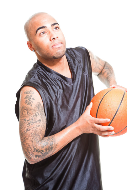 Studio ritratto di giocatore di basket in piedi e tenendo la palla isolata sul bianco. Tatuaggi sulle braccia
. - Foto, immagini