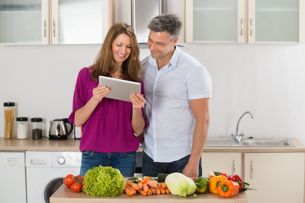 Couple Looking At Recipe On Digital Tablet - Photo, image