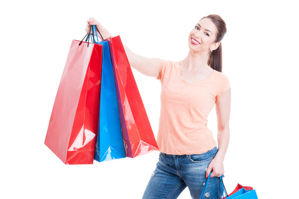 Красивая молодая женщина держит несколько пакетов с покупками и улыбается
 - Фото, изображение