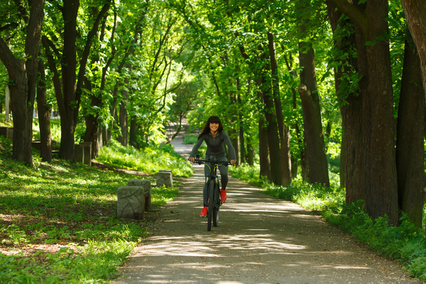 cyclist woman riding a bicycle in park - 写真・画像