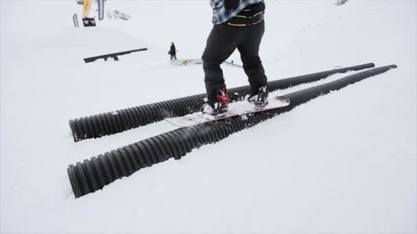 Snowboardista skákat na trampolíně v zasněžené hory. Senzace. Soutěž. Výzva. Lidé. Lyžařské středisko - Záběry, video