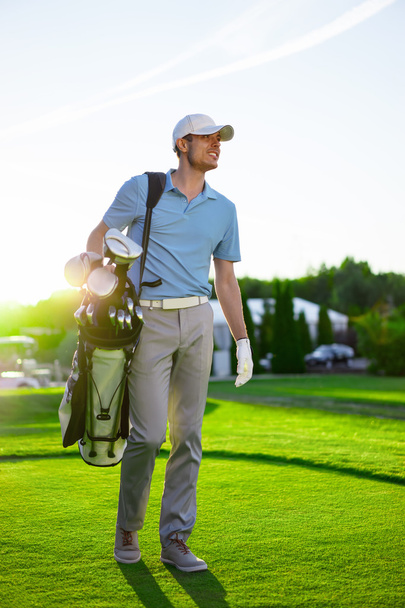 Man met golfclubs outdoors - Foto, afbeelding
