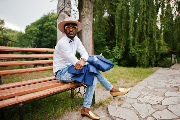 Rich black man sitting on bench at sunglasses, hat and golden sh - Фото, зображення