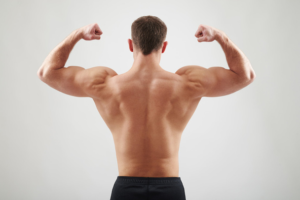 Rücken des athletischen Mannes zeigt Muskeln - Foto, Bild