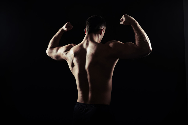 Back view of shirtless guy showing muscles - Φωτογραφία, εικόνα