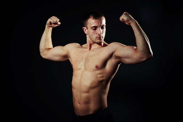 Forró fickó ABS és bicepsz felett fekete háttér - Fotó, kép