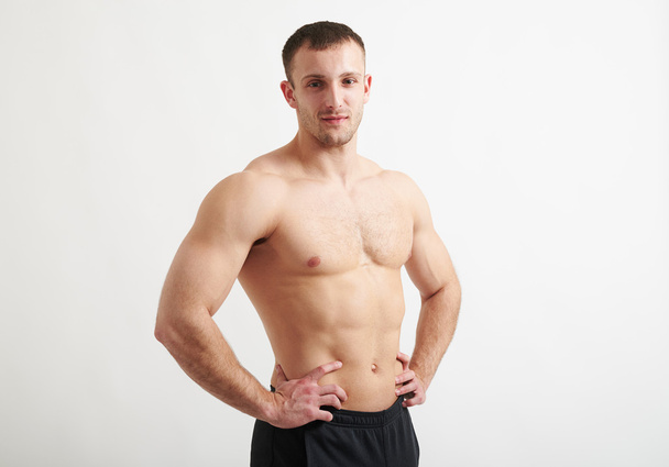 Muscular man over white background with hands on hips - Foto, immagini