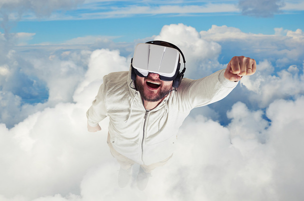 Ο άνθρωπος με τα γυαλιά εικονικής πραγματικότητας που πετούν ανάμεσα στα σύννεφα - Φωτογραφία, εικόνα