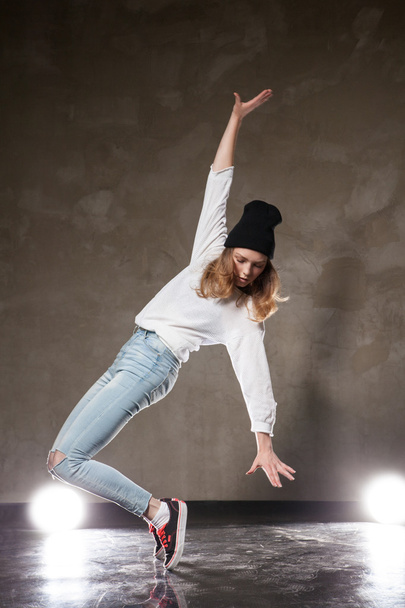 Young woman in black hat dancing on tiptoe - 写真・画像