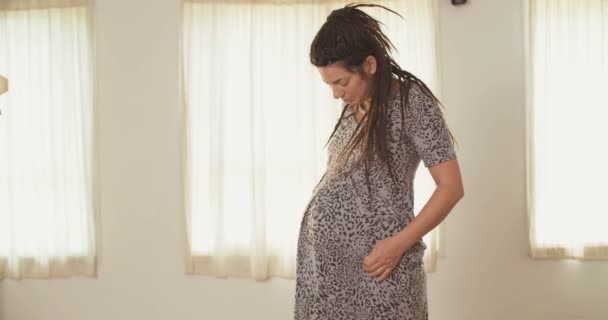 Pregnant woman wearing a dress and caressing her belly - Felvétel, videó