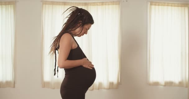 Pregnant woman wearing a dress and caressing her belly - Video