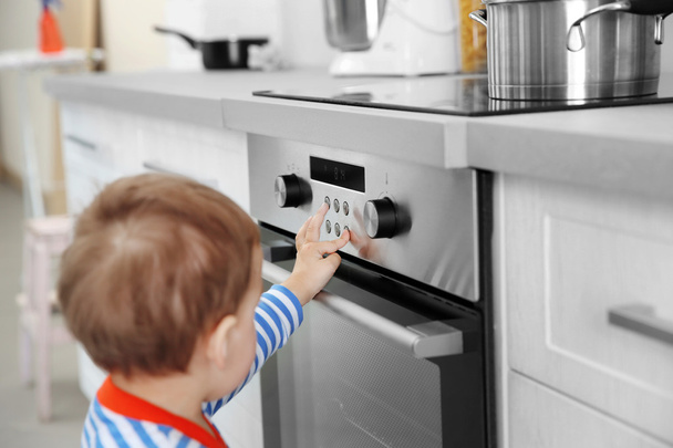 Child playing with electric stove  - Foto, afbeelding
