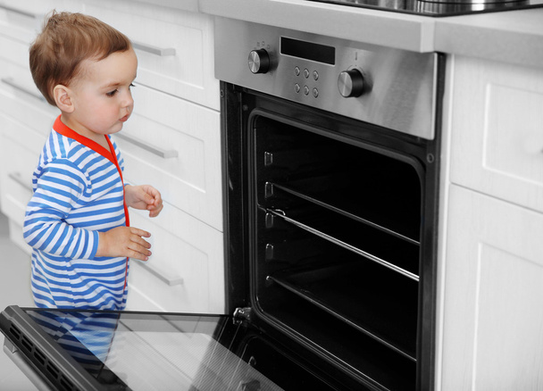Little child playing with oven  - 写真・画像