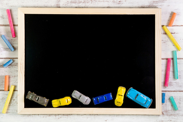 Lege Blackboard en auto speelgoed op houten tafel. Sjabloon mock up f - Foto, afbeelding