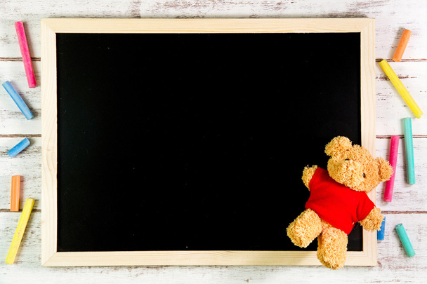 Lege Blackboard en Teddy beer op houten tafel. Sjabloon mock up - Foto, afbeelding