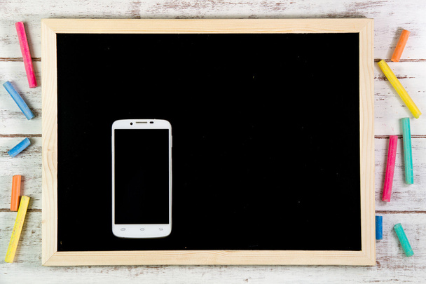 木製のテーブルに黒板とスマートフォン。テンプレート モック u - 写真・画像