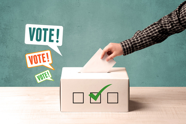 placing a voting slip into a ballot box - Фото, изображение